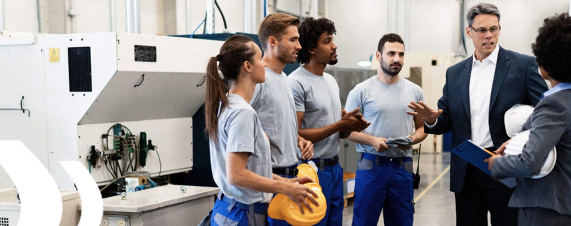 Workshop: Wertstromanalyse und -design – Geschäftsprozesse effizient gestalten Mitarbeiter in der Produktion im Gespräch, symbolisieren den Workshop zur Wertstromanalyse und -design.