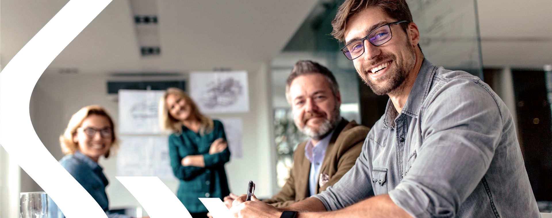 Personen im Büro blicken in die Kamera und symbolisieren 40 Jahre Erfahrung in Beratung und Projektarbeit für Managementsysteme und Zertifizierungen.