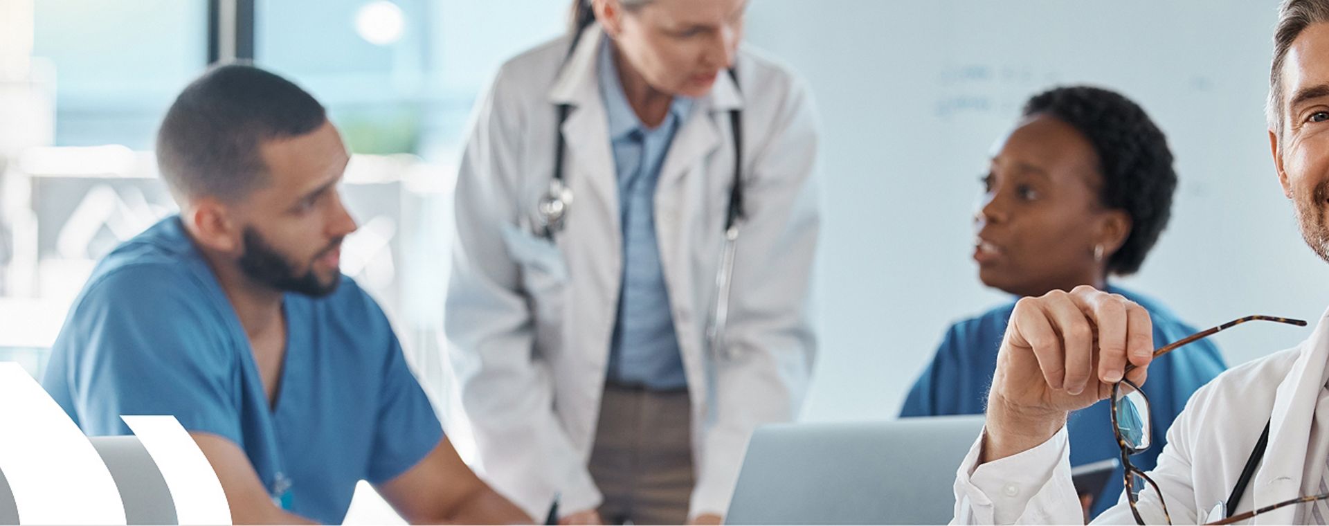 ISO 13485 Schulung – Qualitätsmanagement für Medizinprodukte Fünf Mediziner/innen bei einer Besprechung, symbolisieren die ISO 13485 Schulung zum Qualitätsmanagement für Medizinprodukte.